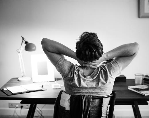 Person reflecting at their workstation